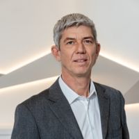 Ein Mann in einem Anzug bei einer Presseveranstaltung von CANCOM Austria.